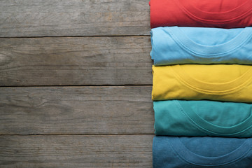 close up of rolled colorful clothes on wood table background