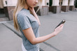 © Photodrive - Modern communication in real life. Girl with gadget, young blonde with mobile phone on street