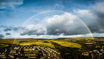 Wall Mural - a full rainbow viewed from the air over a small rural town
