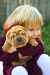 © Veronika - Little cute blond girl hugs shar pei puppy. Lovely friendship with pet