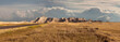 Panorama of badlands national park with vista of mountain range with large clouds in background
