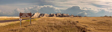 Wide Landscape Panoramic Of Badlands National Park With Signage Entering Into Storm Clouds