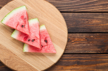 watermelon slices on dark wooden background top view