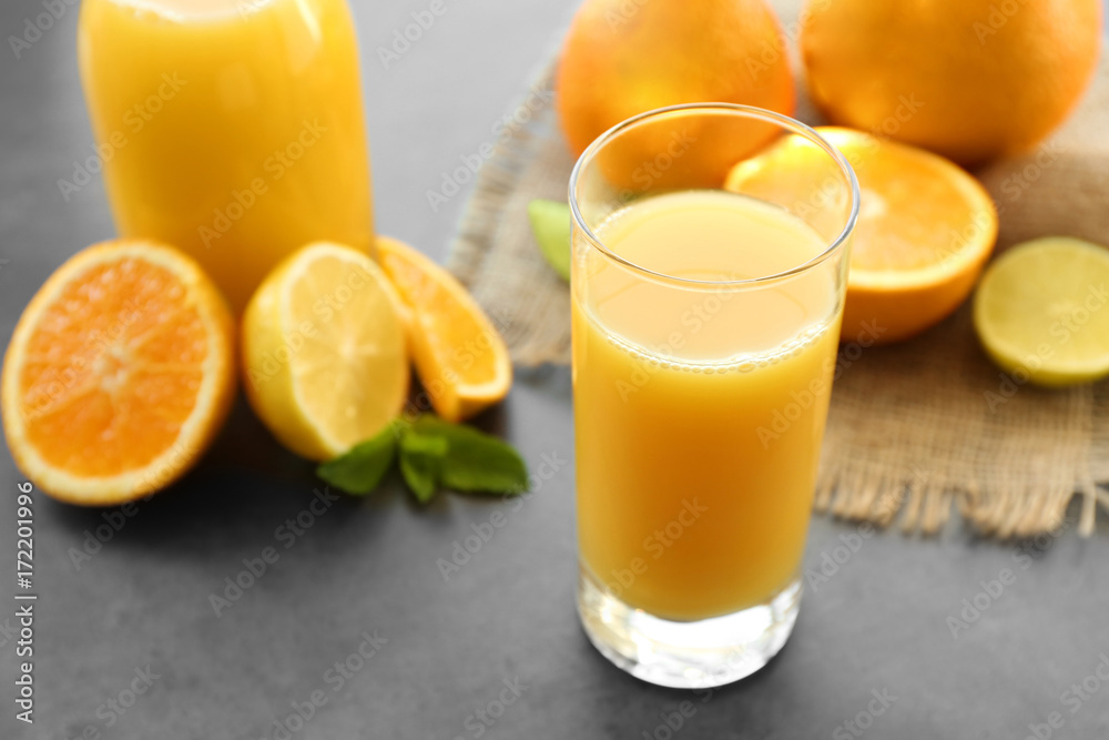 Glass of fresh orange juice on table