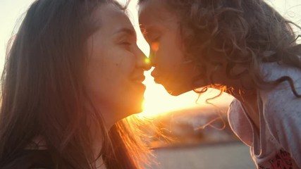 portrait of happy mother and little daughter over sunset