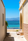 Fototapeta Uliczki - Typical Greek narrow street with view over blue sea. Naxos island. Cyclades. Greece.