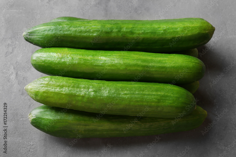 Many green fresh cucumbers on gray table