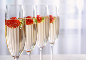 Canvas Print - Glasses of delicious wine with strawberry on light background