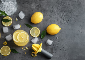 Composition with lemon juice, ice and squeezer on gray background