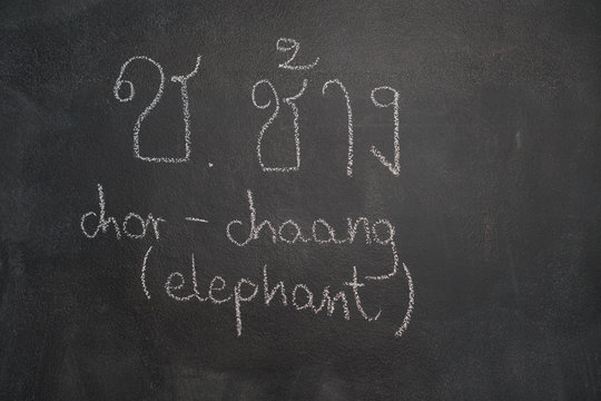 Thai letter written with white chalk on blackboard