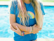 © wendy laurel/Stocksy - blonde girl in rainbow tee with lots of colorful indie bracelets on wrist
