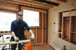 © Rob and Julia Campbell/Stocksy - Carpenter measuring two by four - 2X4- wood inside