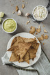 © Tatjana Ristanic/Stocksy - Nacho chips and white bean dip and guacamole