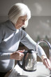 © Lee Avison Photography/Stocksy - senior woman filling a kettle in the kitchen