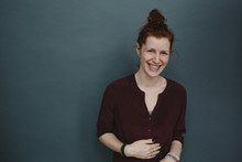 Happy Candid Portrait Of Young Red Head On Solid Grey Blue Background