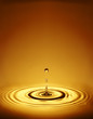 Droplet with ripples in amber liquid