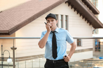 Wall Mural - Male security guard with portable radio, outdoors