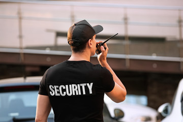 Male security guard with portable radio, outdoors