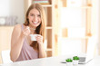 © Africa Studio - Young woman eating yogurt at table