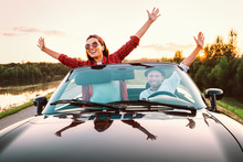Traveling By Car - Happy Couple In Love Go By Cabriolet Car In Sunset Time