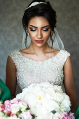 Bride closes her eyes standing with rich wedding bouquet