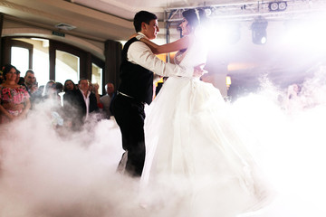 Wall Mural - Smoke surrounds dancing wedding couple in the hall