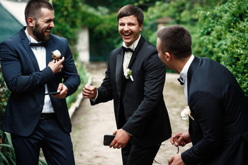 Wall Mural - Groom and groomsmen look funny standing in the garden