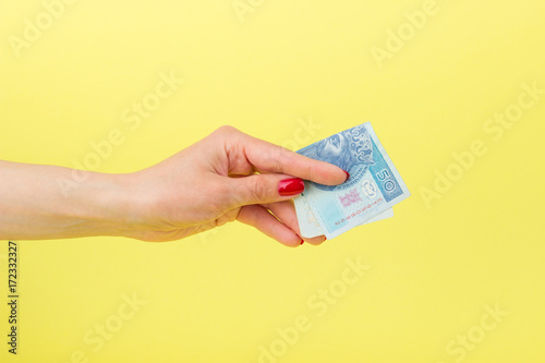 Fotografía Fifty zloty in the woman's hand, yellow background