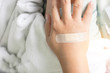 © tumsubin - a plaster close wound on back hand on the bed in hospital
