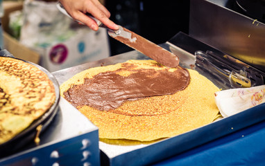 Making of crepes pancakes in open market festival fair.