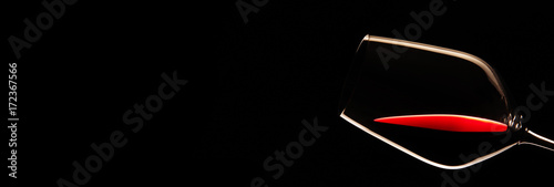 Fotografía Glas mit Rotwein vor schwarzem Hintergrund