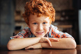 Adorable redhead boy smiling into camera