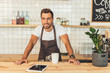 smiling barista at counter with tablet