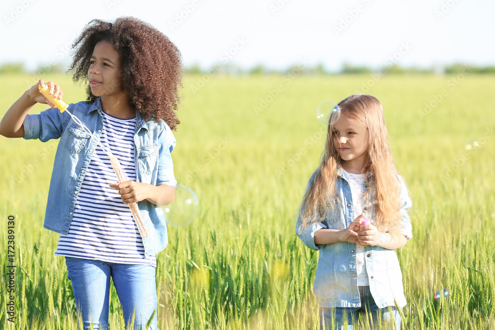 Happy little girls in green field