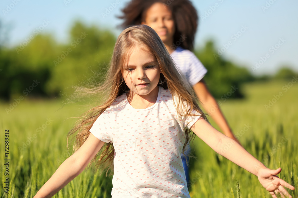 Happy little girls in green field