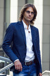 © Alona Dudaieva - attractive man in a business suit and glasses stands near the business center