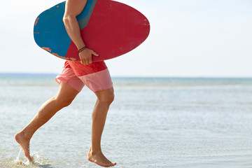 Wall Mural - young man with skimboard on summer beach