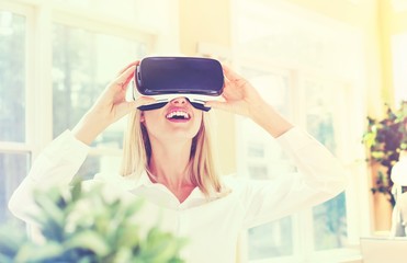 Wall Mural - Happy young woman using a virtual reality headset