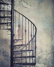 Metal Spiral Staircase Against The Old Wall Background