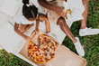 © Kristen Curette Photography LLC/Stocksy - A family having a picnic and eating a box of pizza together