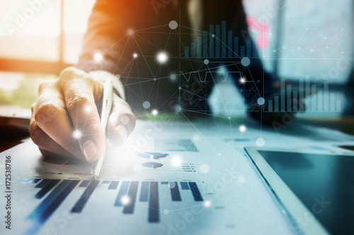 Fotografía Close up Businessman hand holding pen and pointing at financial paperwork with social network diagram