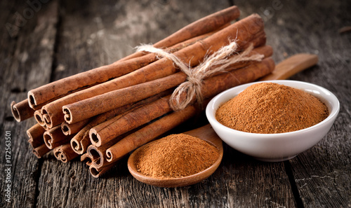 Fotomural Cinnamon powder on table wooden