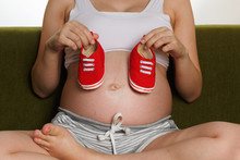 Pregnant Woman Belly Holding Baby Booties. Close Up. Concept Pregnant Healthy And Care.