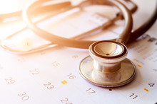Annual Checkup Concept. Stethoscope On The Calendar With Soft-focus And Over Light In The Background