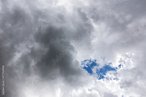 dark overcast sky with rainy clouds and the sun shining through them