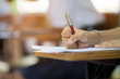 © arrowsmith2 - Closeup to hand of student  holding pen and taking exam in classroom with stress for education test .