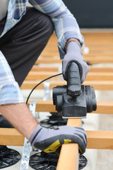 Wall Mural - close up detail of manual worker hands using an electric power tool wood planer