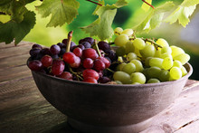 Grapes On Wooden Table And Grape Leaves . Healthy Fresh Fruit Wine Grapes.