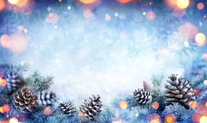 Wall Mural - christmas card - snowy fir branch with pine cones and lights