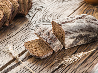 Wall Mural - Sliced black bread on the wooden plank.